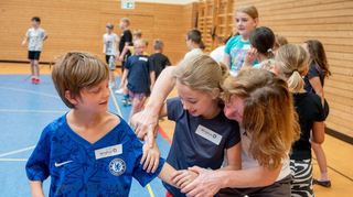 Anja Mokry (rechts), Trainerin an der Wing-Tsun-Schule in Bürstadt, kam durch ihren Sohn zur Kampfkunst. Hier zeigt sie einer Teilnehmerin, wie sie sich gegen einen möglichen Angreifer, hier gespielt von Noah, zur Wehr setzen kann.