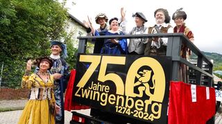 Der Magistrat um Bürgermeister Holger Habich (2.v.l.) präsentierte sich beim Umzug in mittelalterlicher Kleidung auf dem Jubiläumswagen.