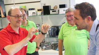 Matthias Ihrig zeigt Maximilian Klöss (rechts) eine gespleißte Glasfaser. Bruder Michael und Vater Rolf (Zweiter und Dritter von links) sehen zu.