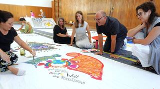 Stefanie Rhein, Andreas Waldenmeier, Luisa Götzinger und Cornelia Trautmann (v.r.) vom Caritas-Team sowie Anne-Sophie Delgado (links) arbeiten an einem Banner für die bevorstehenden Caritastage.