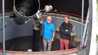 Der Vorsitzende des Vereins Starkenburg-Sternwarte Rainer Kresken (links) und Jürgen Volpp präsentieren das Newtonspiegelteleskop unter der Kuppel der Sternwarte.