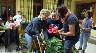 Kerb in Glattbach: Kerbkranzwickeln / zum Kerbkranzwickeln lud die Glattbacher Feuerwehr die Glattbacher Bürger ein. Erstmals mit männlicher Unterstützung 
 wurde an einen Metallring  Blumen (gestiftet von Blumen Müller in Fürth), Tannengeäst und Tuja zu einem Kranz gewickelt. Nach der Kerbausgrabung am selben Abend wurde dieser dann am Samstag aufgehängt.
Foto: Jürgen Strieder