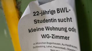 Ein Zettel mit der Aufschrift „22-jährige BWL-Studentin sucht kleine Wohnung oder WG-Zimmer“ hängt an einer Wand in München-Haidhausen.