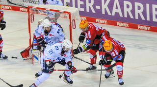 Kampf um den Puck am Tor beim Spiel Adler Mannheim gegen Fischtown Pinguins Bremerhaven(in rot).