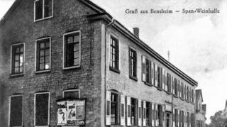Von der Gewerbeschule im Neubaugebiet zur Bensheimer Traditionsgaststätte: Die Geschichte des ursprünglich als Schule angelegten Gebäudes in der Grieselstraße wurde maßgeblich von einem aus Spanien eingewanderten Fachmann für Korkverschlüsse geprägt. Das Bild links zeigt Claras Spanische Weinhalle als malerisches Postkartenarchiv, vermutlich aus den 1920er Jahren.