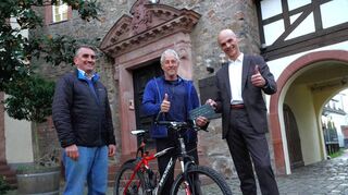 Als Prämie überreichte Bürgermeister Holger Habich (rechts) und Stadtverordnetenvorsteher Andreas Kovar (links) dem Gewinner einen Gutschein vom örtlichen Fachhändler „Rat &amp;Tat“.