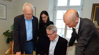 Landrat Engelhardt (sitzend) bei der Unterschrift für den Kreis Bergstraße unter das Beitrittsdokument zur Kulturstiftung gemeinsam mit Raza Bujupaj, Kulturmanagerin des Kreises Bergstraße, Professor Joachim-Felix Leonhard (links) und Zwingenbergs Bürgermeister Holger Habich.