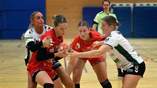 Dionne Visser wird beim Heimspiel der Junior-Flames gegen Aldekerk im Angriff von zwei Gegenspielerinnen angegangen; Johanna Borrmann (im Hintergrund) beobachtet die Szene.