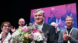 Hans-Ulrich Rülke (M), der neu gewählte Landesvorsitzende der Südwest-FDP, steht beim Landesparteitag in der Schwabenlandhalle nach seiner Wahl mit einem Blumenstrauß auf dem Podium. Rechts steht Pascal Kober, der zum stellvertretenden Landesvorsitzenden gewählt wurde. Links steht Judith Skudelny, Generalsekretärin der FDP Baden-Württemberg.