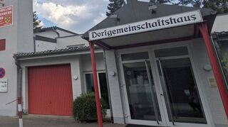 Für Personen mit Bewegungseinschränkungen ist das Betreten und Verlassen des Dorfgemeinschaftshauses durch die zwei aufeinanderfolgenden Doppeltüren derzeit mit einigen Schwierigkeiten verbunden.