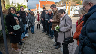 Veranstaltung zum Holocaust-Gedenktag beim Synagogenverein Auerbach: Michael Löbl (4.v.re. ) erinnerte an ermordete Juden und Jüdinnen, weiße Rosen werden an den Stolpersteinen in der Bachgasse niedergelegt. Links im Bild die Vorsitzende des Auerbacher Synagogenvereins, Ursula Schlosser.