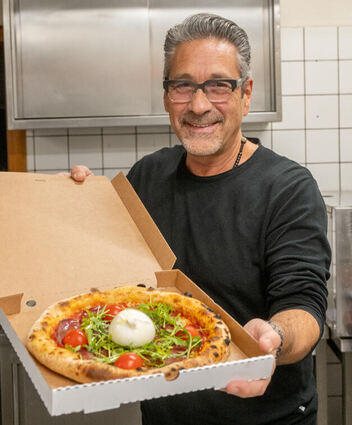 Toni Di Sciascio mit einer Pizza frisch aus dem Ofen in seinem Restaurant Rossini in Bensheim.