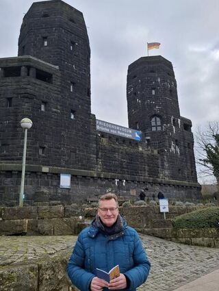 Recherche vor Ort: Autor Konstantin Groß vor dem Turm der Brücke von Remagen.