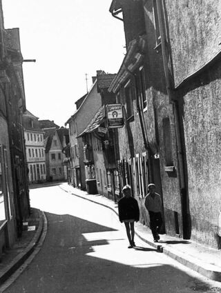 Als idyllische Altstadtgasse erscheint die Straße Am Rinnentor auf diesem wohl in den 1960er Jahren aufgenommenen Foto, das sich im Archiv der Stadt Bensheim befindet. Das Gaststättengebäude bildet mit den westlich anschließenden Häusern eine geschlossene Reihe bis zu einem schmalen Durchlass vor dem nächsten erheblich größeren Haus.