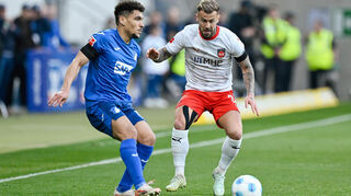 Hoffenheims Valentin Gendrey (l) und Heidenheims Niklas Dorsch kämpfen um den Ball.