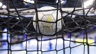 Ein Ball liegt auf einem Netz im Tor.