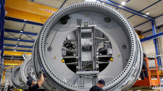 Bei einem Anlagenbauer arbeiten Mitarbeiter an einer Nabe für die Turbine einer Windkraftanlage.