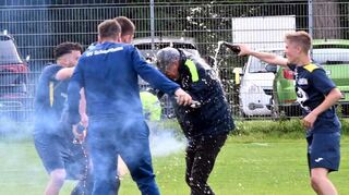 Ausgelassener Jubel um und mit Trainer Wolfgang Jäger (2. v. re.).
