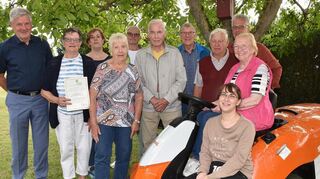 Geehrte Mitglieder des Obst- und Gartenbauvereins Einhausen und des Vorstands mit Bürgermeister Helmut Glanzner (links) und dem Aufsitz-Rasenmäher.