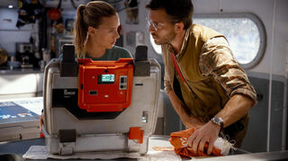 Scarlett Johansson (l) als Zora Bennett und Jonathan Bailey als Dr. Henry Loomis in einer Szene des Films „Jurassic World: Die Wiedergeburt“. Der Film kommt am Donnerstag in die deutschen Kinos.