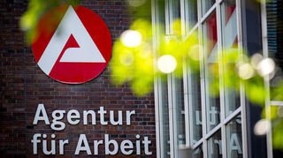 Der Schriftzug „Agentur für Arbeit“ hängt an einem Gebäude.