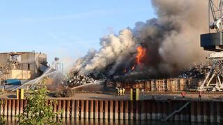 Ein Schrotthaufen auf einem Recyclingbetrieb im Mannheimer Industriehafen steht in Flammen.
