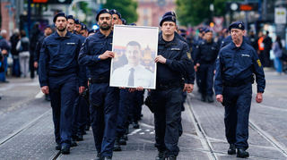 Bei einem Trauermarsch nach der Messerattacke von Mannheim tragen Polizisten das Bild von Rouven Laur durch die Mannheimer Innenstadt.