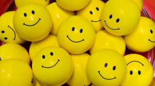 Smileys auf kleinen gelben Kunststoffbällen.