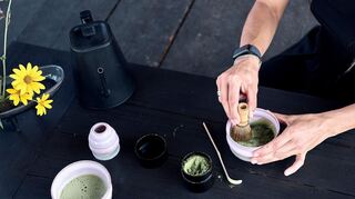 Das Matcha-Pulver wird mit Wasser und einem Besen schaumig geschlagen.