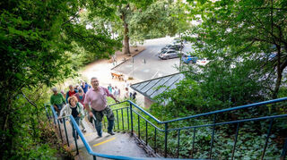 Beim Themenrundgang des Auerbacher Kur- und Verkehrsvereins führte Ralph Stühling (vorne) die Teilnehmer oberhalb der „Frihmess“ die Treppen hinauf zum Gedenkstein für Willi Giesin.
