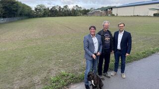 Das Bild zeigt (v.li.) Sebastian Clever (Bürgermeister von Zwingenberg) mit Hündin „Maia“, Landwirt Peter Bitsch und Sebastian Bubenzer (Bürgermeister von Alsbach-Hähnlein) vor der Fläche, die für die Hundespielwiese vorgesehen ist.