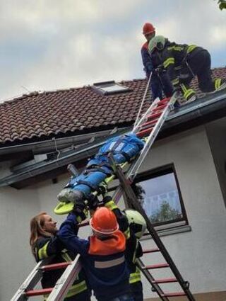 Über eine zur Rutsche umfunktionierte Steckleiter brachten die Feuerwehrleute den verletzten Handwerker schonend vom Dach in einen sicheren Bereich.