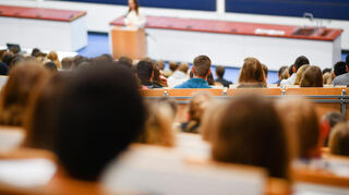 Studenten sitzen in der Universität Heidelberg in einem Hörsaal.