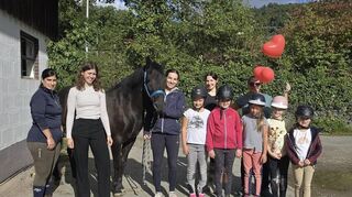 Das Foto zeigt das neue Schulpferd Karino, einige Vorstandsmitglieder und die Mitglieder der Kinderreitstunde.