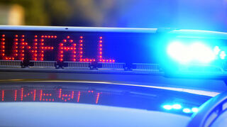 Auf einem Polizeifahrzeug warnt eine Leuchtschrift vor einer Unfallstelle.