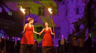 Stelzenläuferinnen mit Fackeln beim Heppening-Festival im Kurmainzer Amtshof.