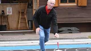Karl Hoger zeigt, wie das richtige Eisstockschießen gelingt.