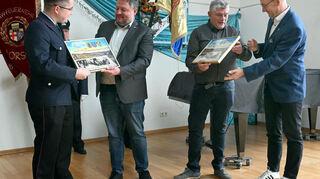Feuerwehrvereinsvorsitzender Robin Gröger (l.) und Bürgermeister Schönung nahmen die gerahmten Bilder als Gastgeschenke in Empfang.