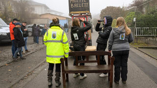 Während Bauhofmitarbeiter die Ruhebank durch den Ort tragen, sucht das „Verschönerungsteam“ fieberhaft nach der vermissten Bank.