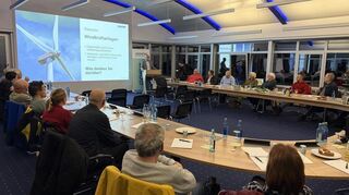 Teilnehmerinnen und Teilnehmer des Klimabündnis Bergstraße verfolgen in den Räumen der GGEW AG die Präsentation von Vorstand Carsten Hoffmann zur regionalen Energiewende.